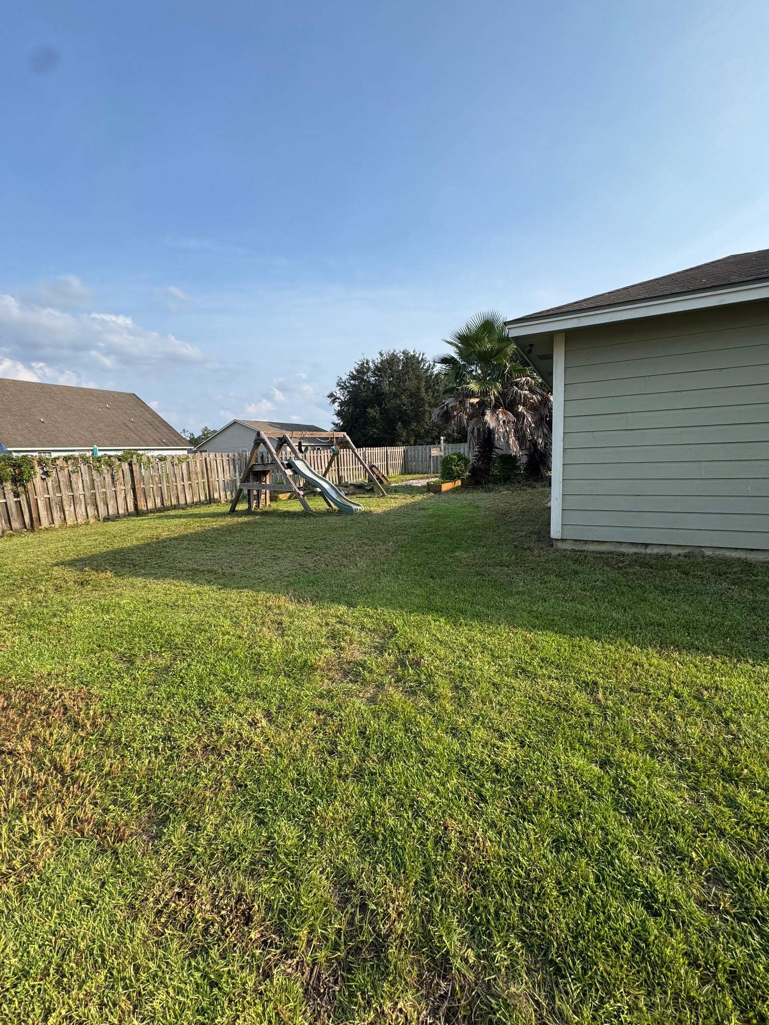Cut backyard lawn around a playset after recovery work