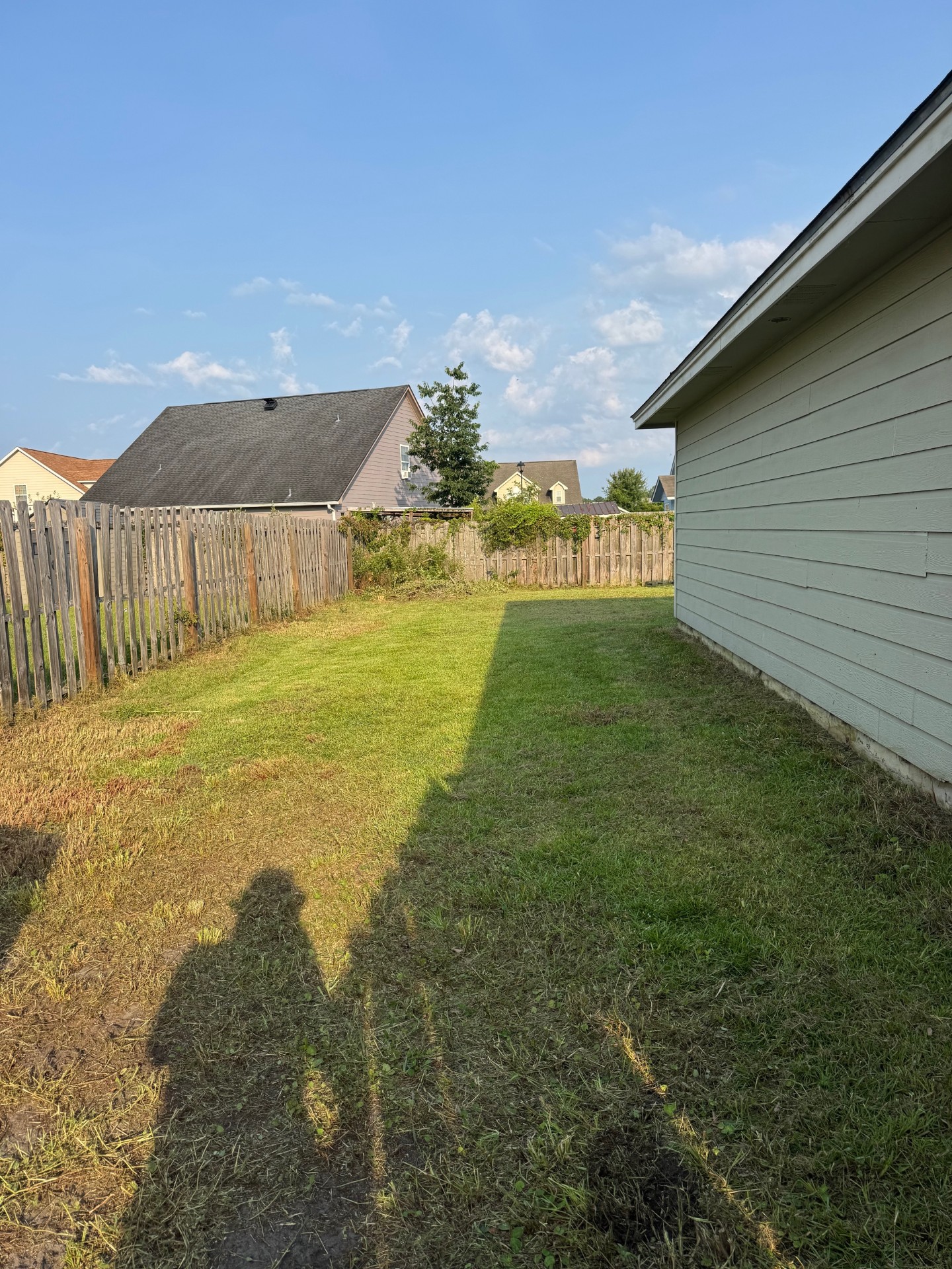 Cut side yard beside a home and fence after recovery work