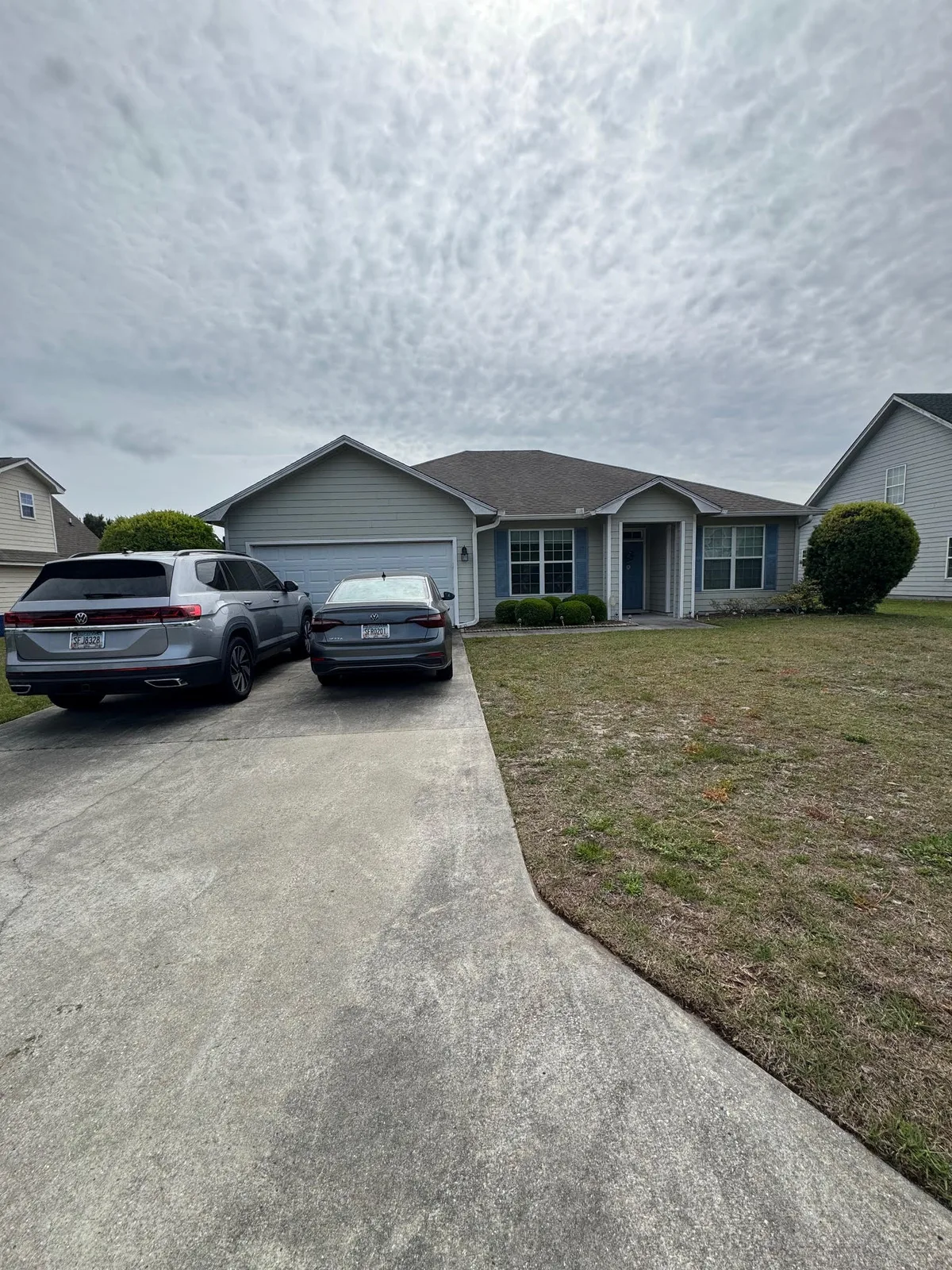 Residential home and maintained lawn beside a concrete driveway